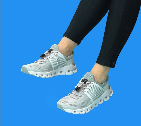 Allen's Bootery white reflective Xpand quick release elastic laces installed on grey athletic sneakers