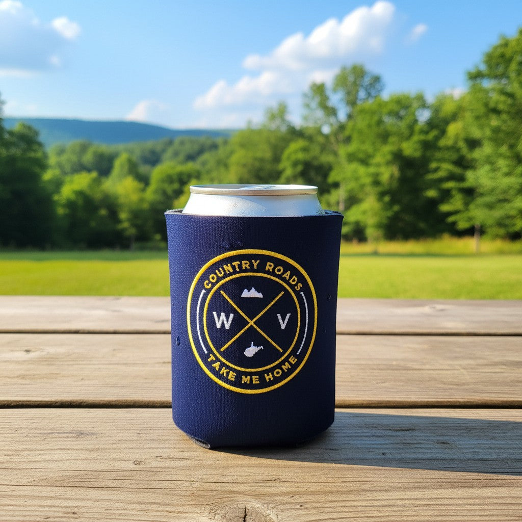Allen's Bootery navy neoprene can koozie with embroidered West Virginia Country Roads seal on a wooden table outdoors
