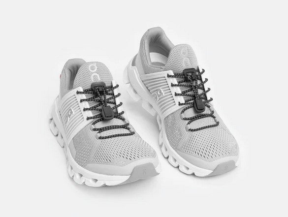 Allen's Bootery Xpand Laces black reflective elastic laces installed on grey performance sneakers for easy slip-on.