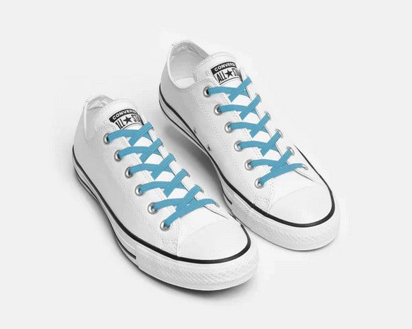 Allen's Bootery Xpand Laces Original in breezy blue installed on white low-top sneakers for a no-tie fit.