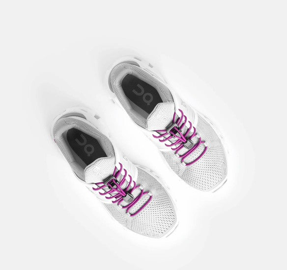 Allen's Bootery Xpand magenta elastic quick-release laces installed on white running shoes, top-down view.