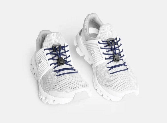 Allen's Bootery Xpand navy blue elastic quick release laces installed on white athletic sneakers