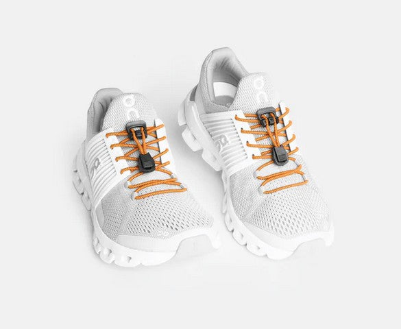 Allen's Bootery Xpand neon orange elastic quick release laces installed on white athletic sneakers