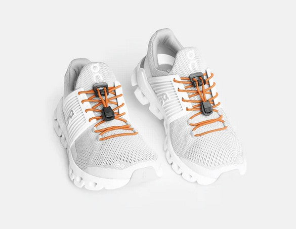 Allen's Bootery Xpand quick release elastic laces in pumpkin orange installed on white athletic running shoes