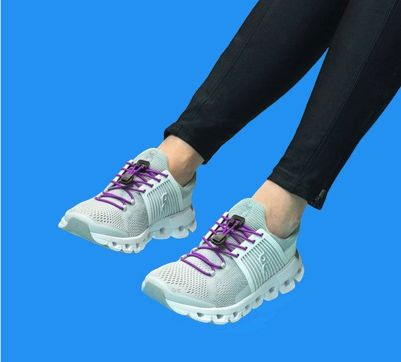 Allen's Bootery Xpand Laces purple elastic quick-release system installed on light grey athletic sneakers