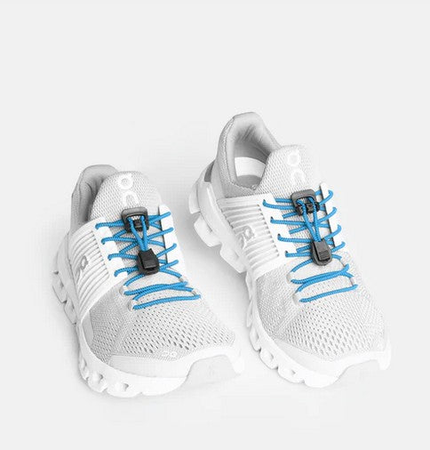 Allen's Bootery Xpand sky blue elastic quick release laces installed on white athletic sneakers with locking anchors.