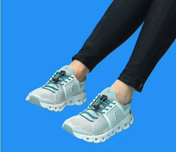 Allen's Bootery Xpand teal elastic quick release laces installed on light grey athletic sneakers
