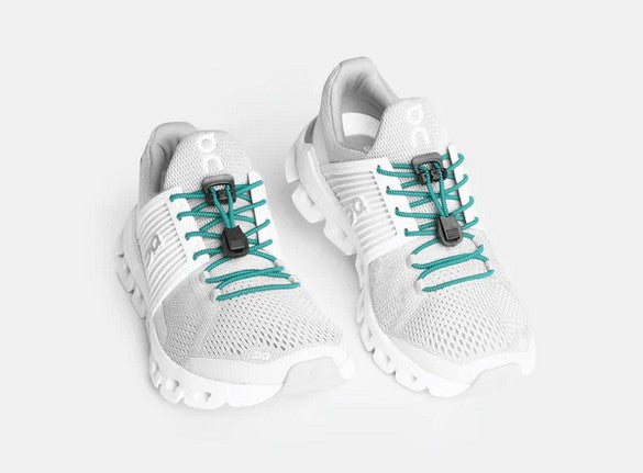 Allen's Bootery Xpand teal elastic quick release laces installed on white athletic sneakers with black locking anchors